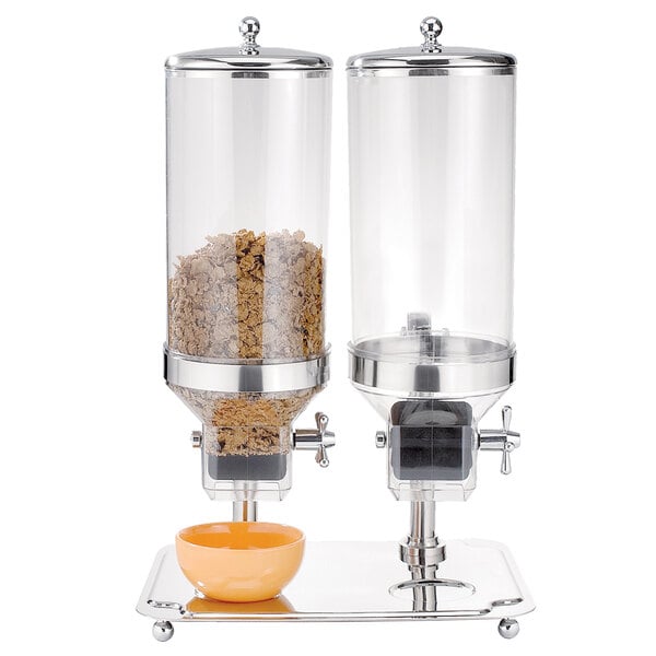 An Eastern Tabletop double cereal dispenser with two glass canisters and a bowl of cereal on top.