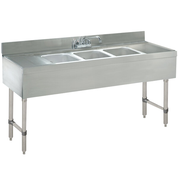 A stainless steel Advance Tabco underbar sink with three compartments and two drainboards.