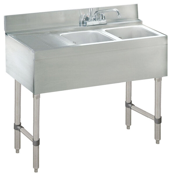 A stainless steel Advance Tabco underbar sink with two bowls and a right side drainboard.
