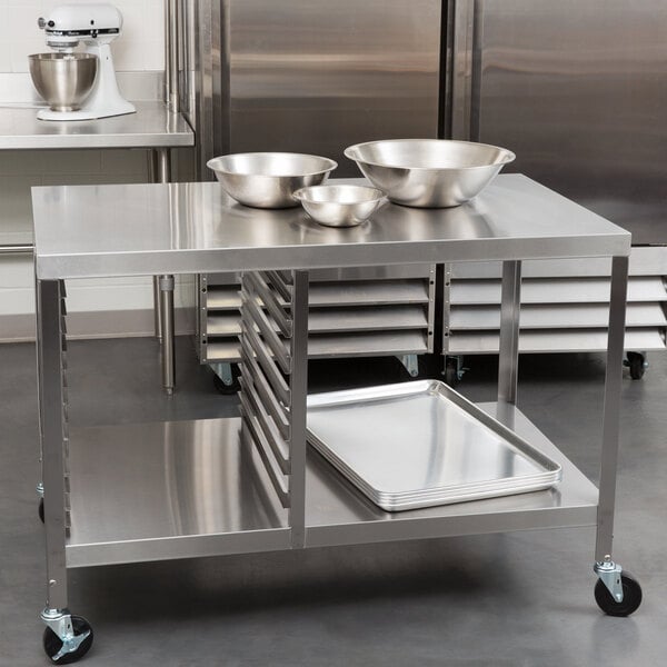 A Lakeside stainless steel work table with sheet pan storage and bowls on top.