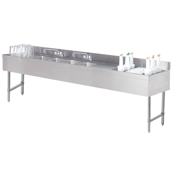 A stainless steel Advance Tabco underbar sink with four compartments and two ice bins.
