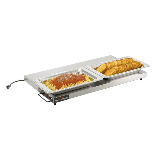 A Vollrath heated shelf warmer with two trays of food on a table.