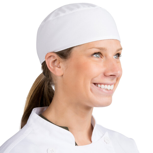A woman wearing a white Headsweats customizable chef skull cap.
