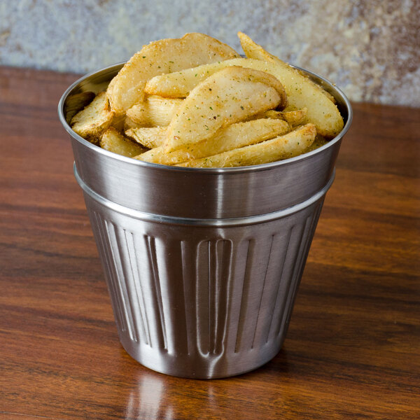 An American Metalcraft mini stainless steel round trash can filled with fries on a table.