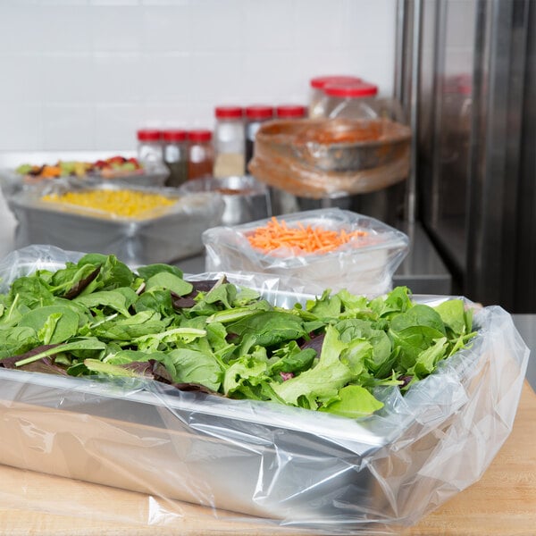 A tray of lettuce in a silver steam table pan lined with a plastic bag.