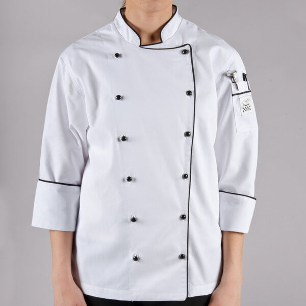 A woman wearing a white Chef Revival executive long sleeve coat with black piping.