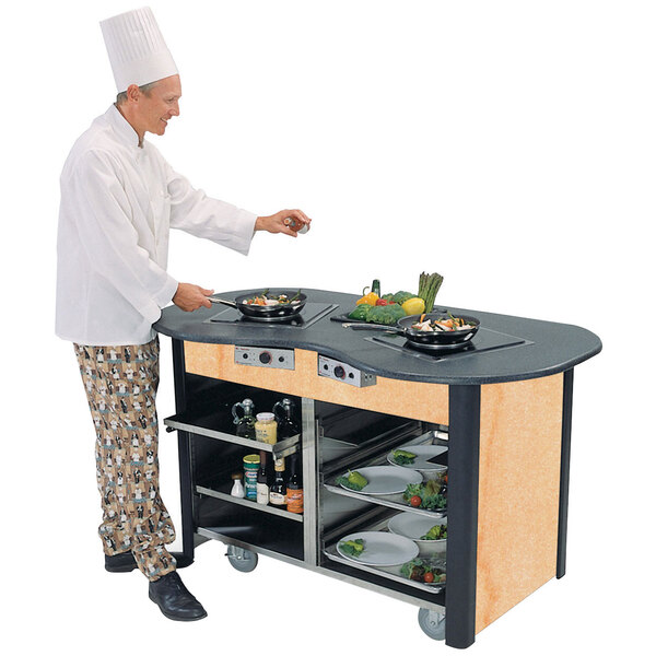A chef using a Lakeside stainless steel induction cooking cart to prepare food.