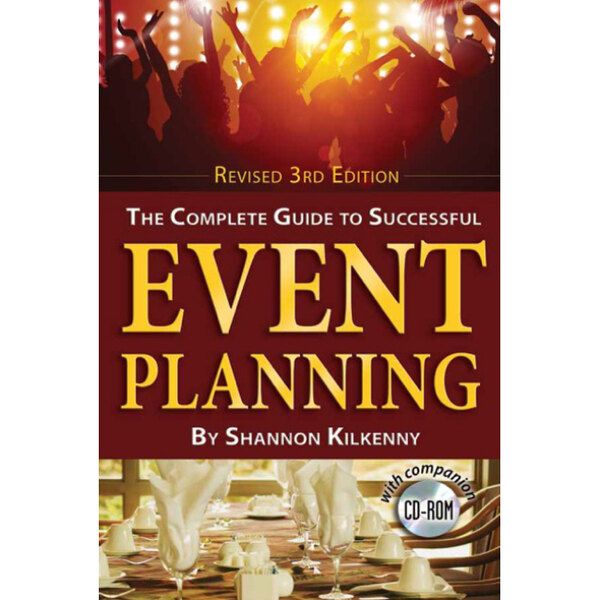 The complete guide to successful event planning book on a table with plates and glasses.