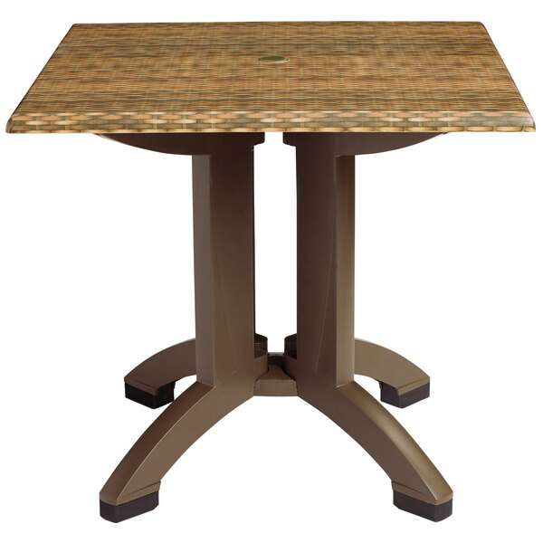 A Grosfillex square pedestal table with a wicker top.