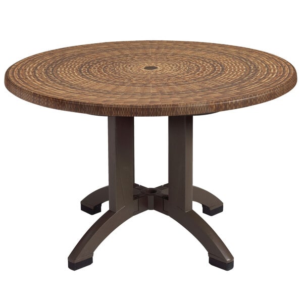 A Grosfillex round pedestal table with a wicker top.
