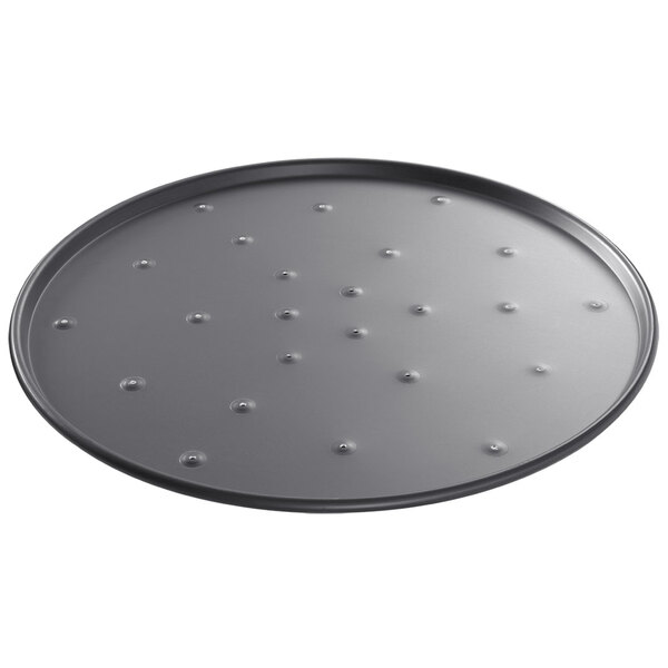 A Chicago Metallic BAKALON round aluminum pizza pan with holes in it.