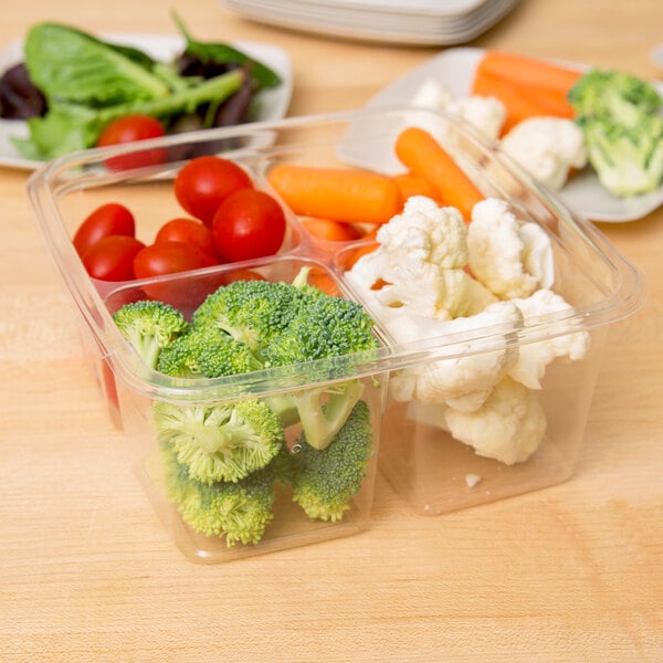 A Fabri-Kal clear plastic deli container with broccoli, cauliflower, and carrots.