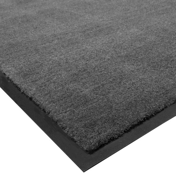 A close-up of a charcoal gray carpet mat with black edges.