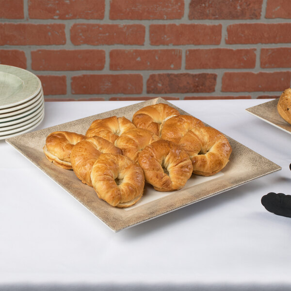 A plate of pastries on a table with Thunder Group Jazz melamine plates with a crackle-finished border.
