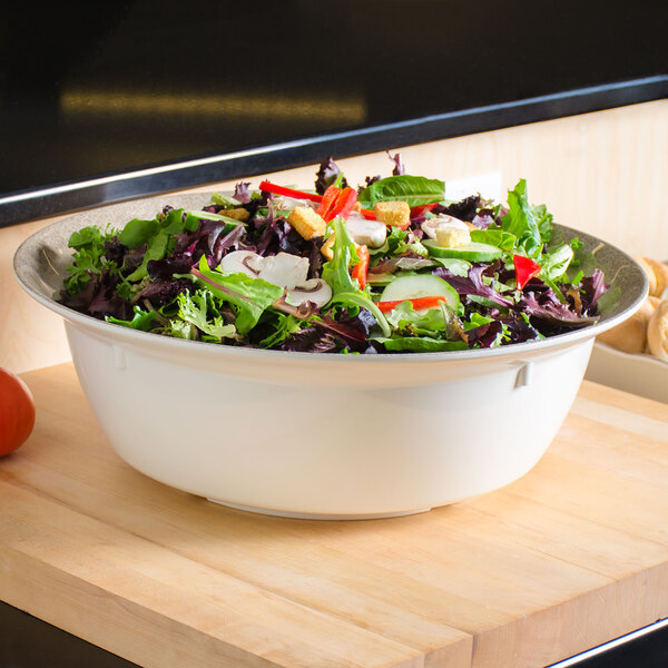 A Thunder Group Jazz melamine bowl with a crackle-finished border filled with salad, mushrooms, and vegetables on a counter.