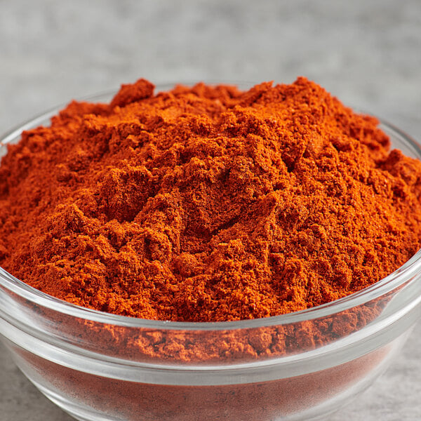 A bowl of Regal smoked paprika powder on a table.