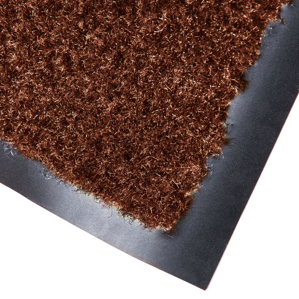 A close up of a chocolate brown carpet mat with a black backing.