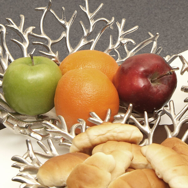 An Eastern Tabletop cast aluminum branch display tray with a bowl of fruit and bread on a table.