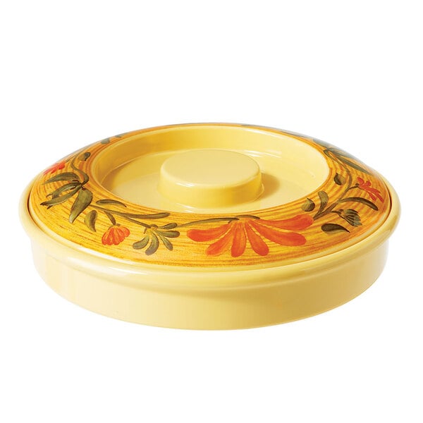 A yellow circular melamine tortilla server with a flower design on the lid.