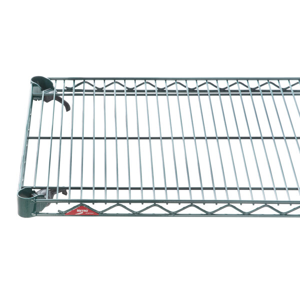 A green Metroseal wire shelf on a metal grid.