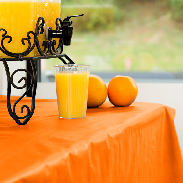 A glass of orange juice on a Sunkissed Orange table cover.