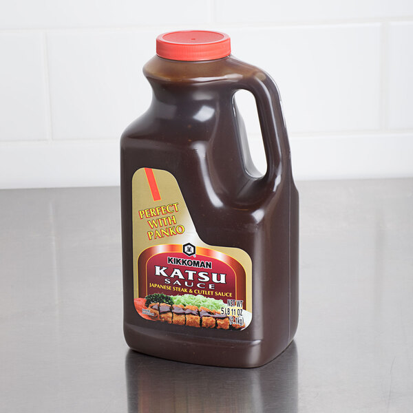 A brown plastic container of Kikkoman Katsu Sauce on a counter.