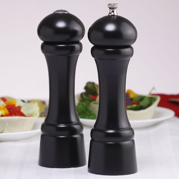 Two black Chef Specialties Windsor Ebony pepper mills on a table.