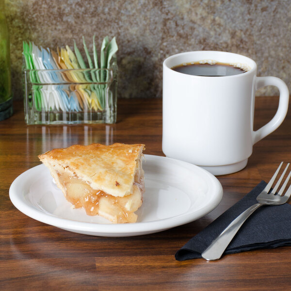 A white Fiesta® appetizer plate with a slice of pie on it next to a mug of brown liquid.
