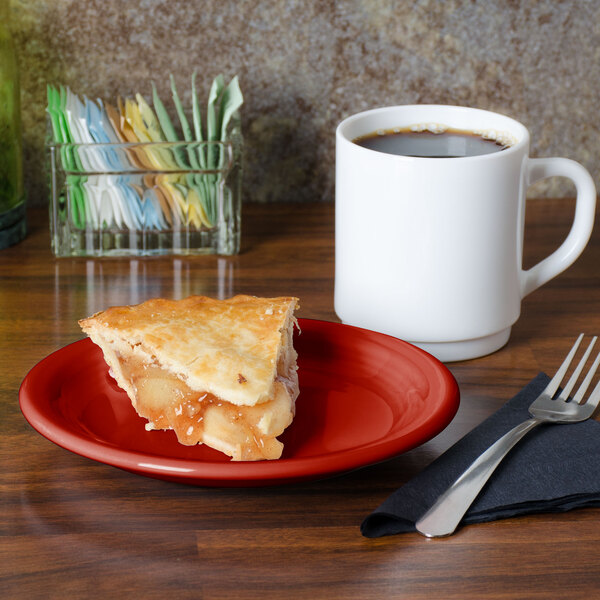 A slice of apple pie on a Fiesta® Scarlet plate next to a cup of coffee.