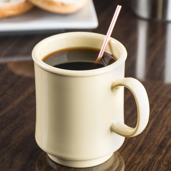 A GET Diamond Harvest Squash Tritan mug of coffee with a straw.
