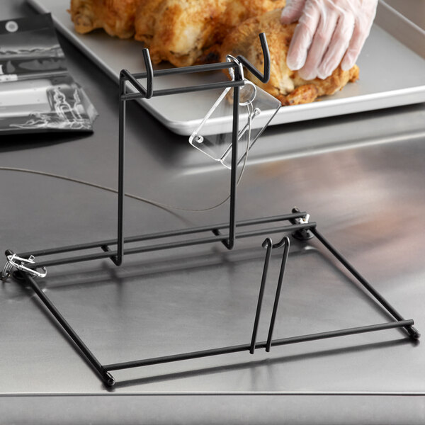 A person in gloves using a countertop rack to hold a chicken.