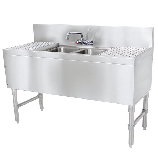 A stainless steel Advance Tabco underbar sink with 2 bowls, 2 drainboards, and a faucet.