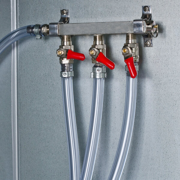 A Beverage-Air draft manifold with 2 inlets and 2 outlets connected to a metal wall.