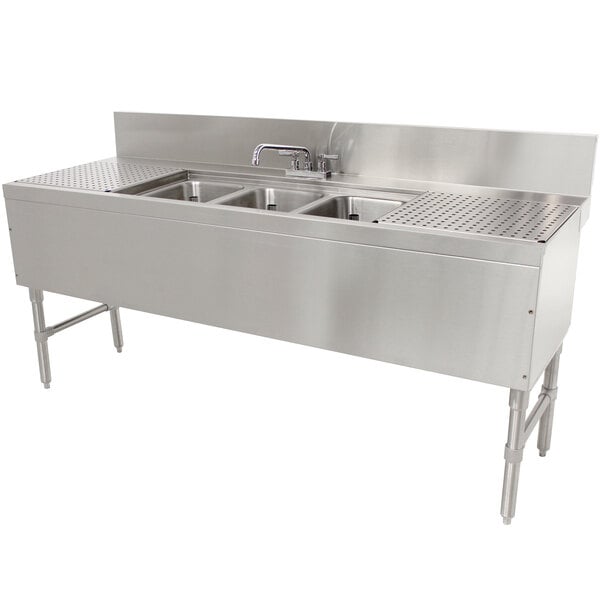 An Advance Tabco stainless steel underbar sink with 3 compartments, 2 drainboards, and a deck mount faucet.