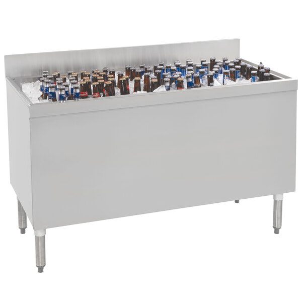 A large stainless steel Advance Tabco beer box on a counter filled with brown bottles.