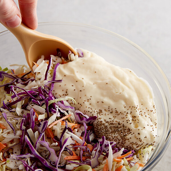 A bowl of shredded cabbage with white dressing.