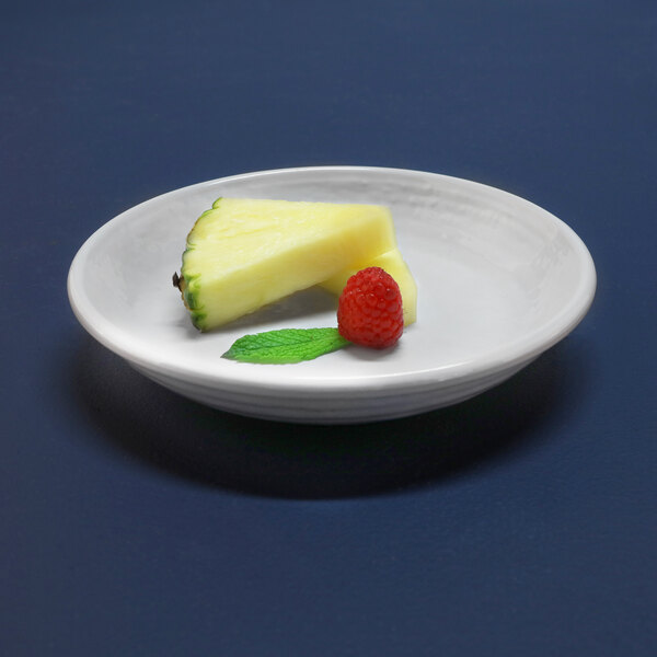 A white Elite Global Solutions melamine bowl with pineapple and raspberries on it.