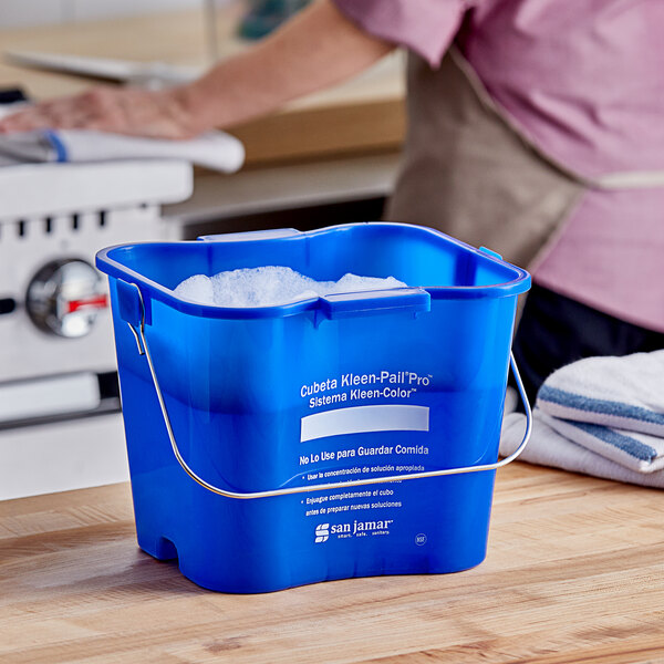 A blue San Jamar Cleaning Kleen-Pail Pro bucket with white text on it and a handle.
