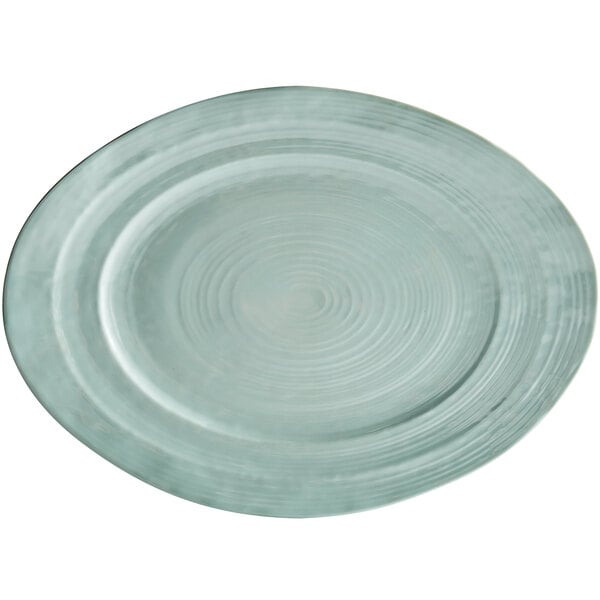 A mint green irregular oval serving dish with a spiral design on it.