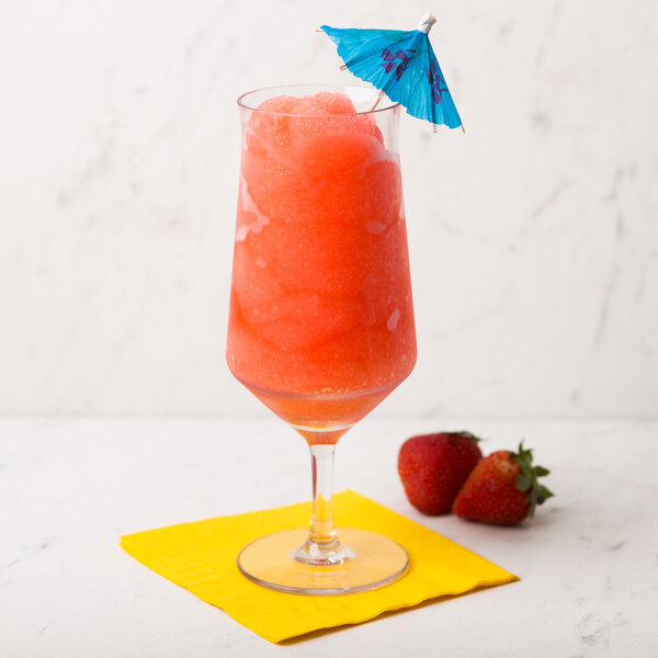 A customizable GET Tritan plastic goblet filled with a strawberry drink and strawberries with a blue umbrella on the rim.