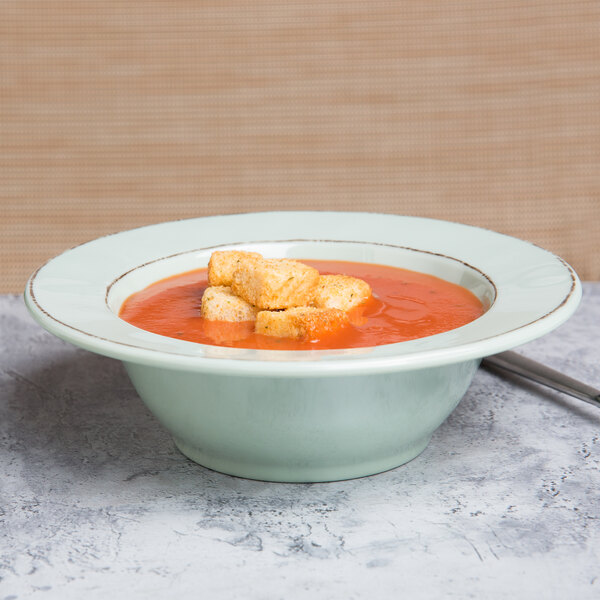 A bowl of soup with croutons and tomato in a Elite Global Solutions Hemlock bowl.