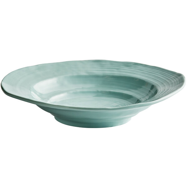 A close-up of an Elite Global Solutions Della Terra mint green melamine bowl with a blue rim.