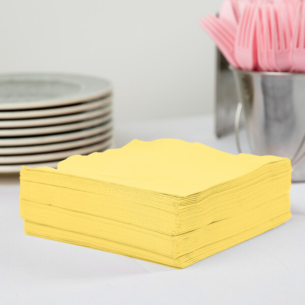 A stack of Creative Converting Mimosa Yellow paper napkins.