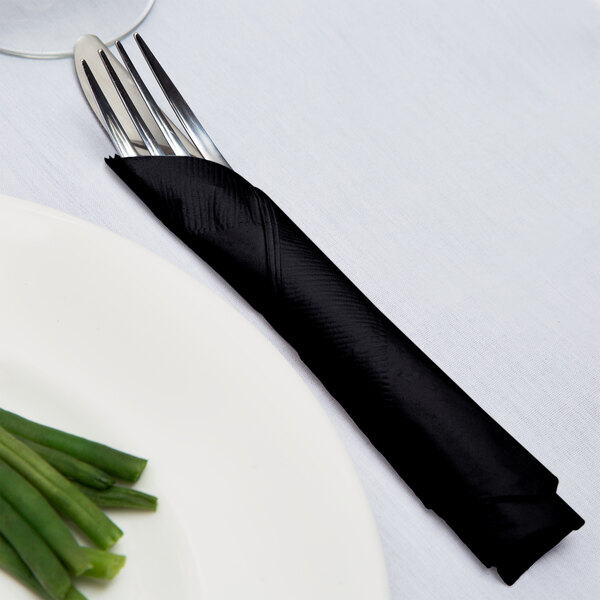 A fork and knife wrapped in a black velvet Creative Converting luncheon napkin.