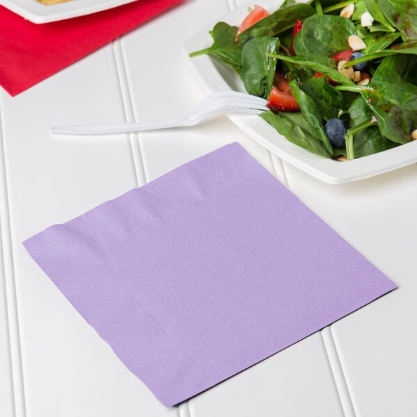 A plate of salad with a Creative Converting Luscious Lavender purple napkin on it.