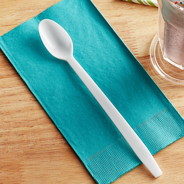 A white plastic Choice soda/sundae spoon on a blue napkin.