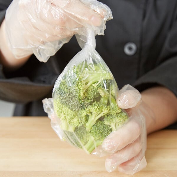 A hand holding a LK Packaging plastic food bag of broccoli.