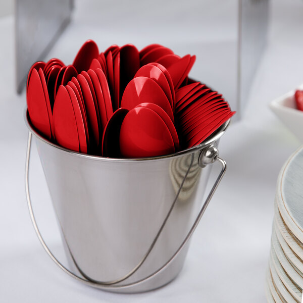 A bucket filled with Classic Red plastic spoons.