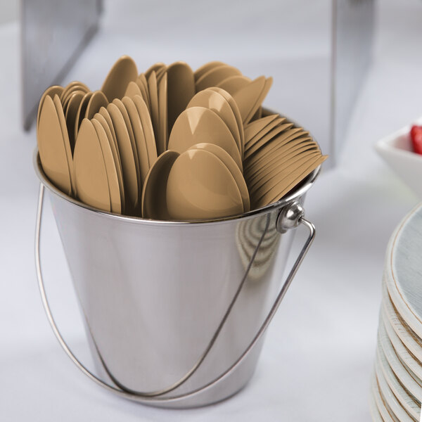 A bucket filled with Creative Converting glittering gold plastic spoons and forks.