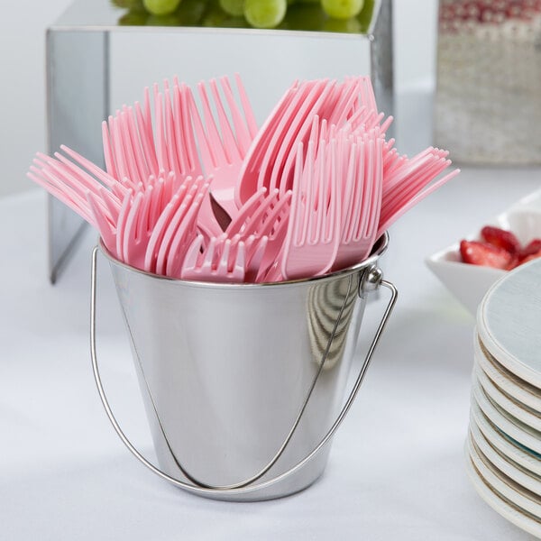 A bucket of pink plastic forks.